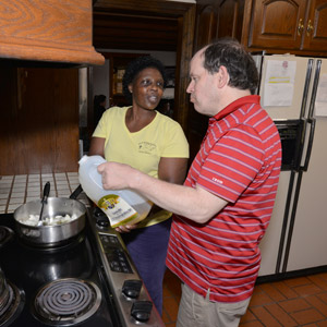 A female HMEA staff working with a man who is supported in HMEA's residential program