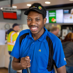 A man of color who is served by HMEA's TRACS program at the restaurant where he works